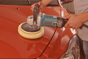 auto technician buffing an automobile after a vehicle collision