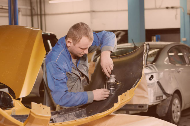 auto body mechanic fixing wheel well after car accident